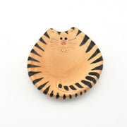 Ceramic dish shaped like a tiger with black stripes on a white background