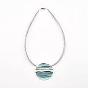 Necklace with a round, marbled pendant on a white background