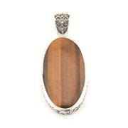 Pendant with brown oval stone and silver frame on a white background