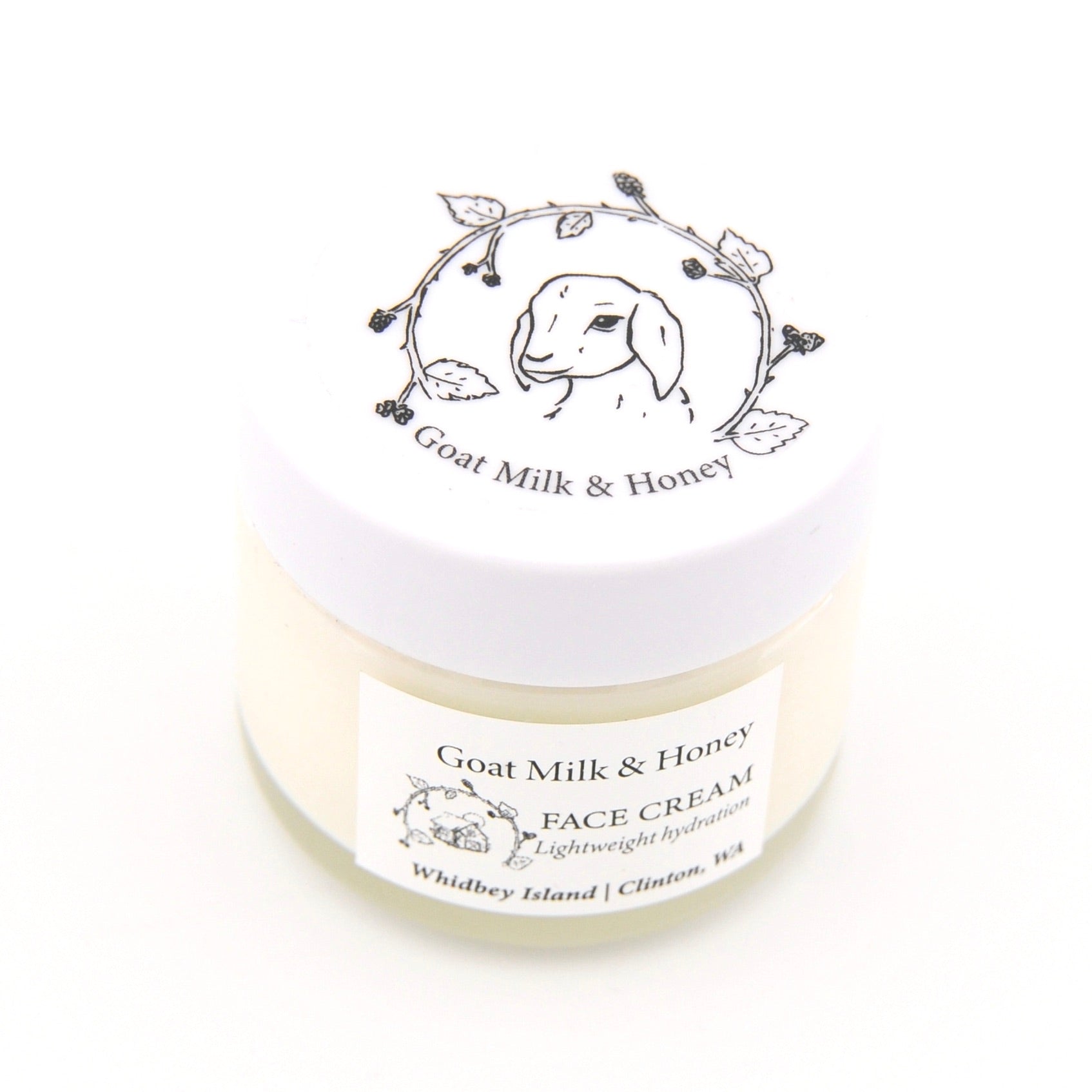 Jar of goat milk and honey face cream with branding on a white background