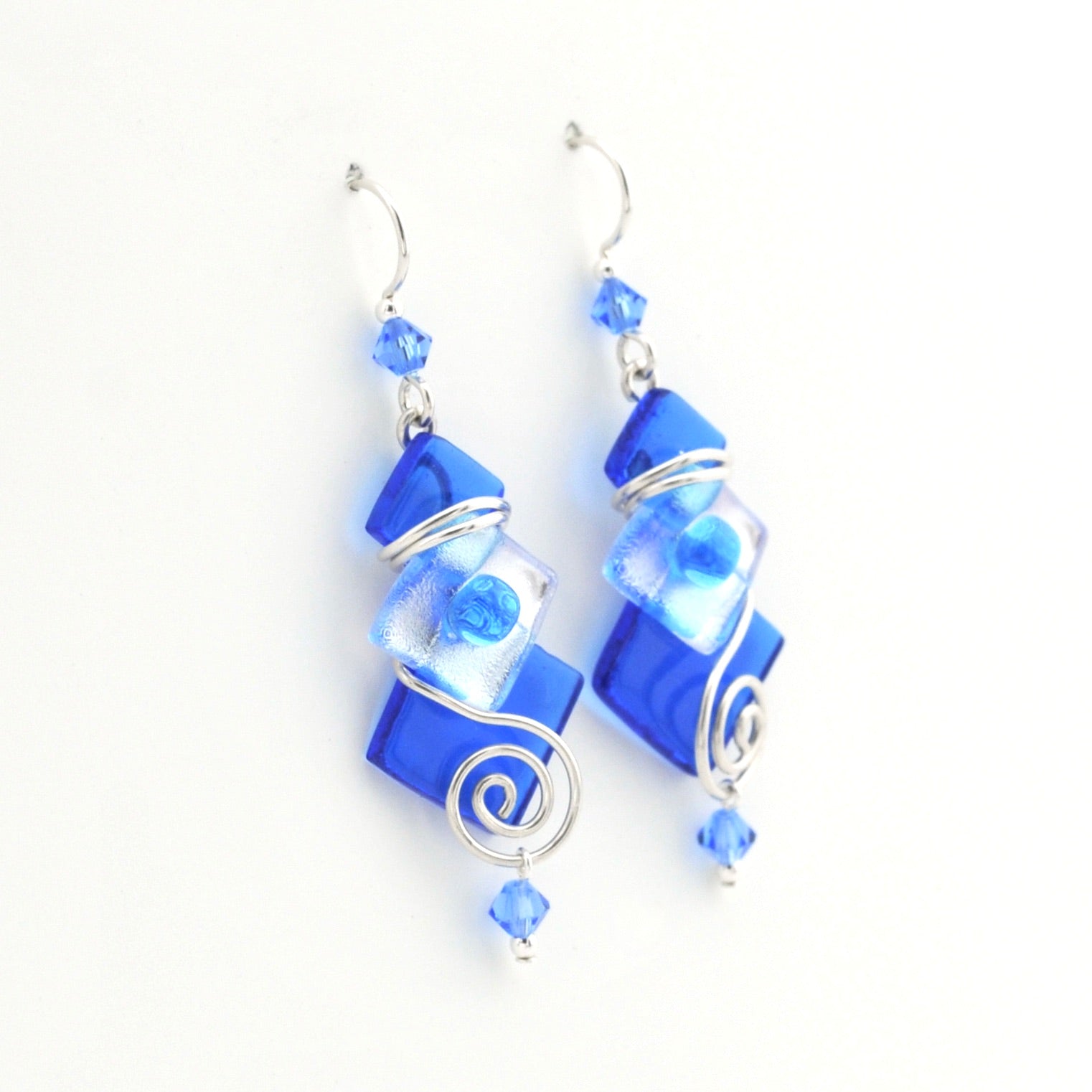 Blue glass earrings with silver accents on a white background