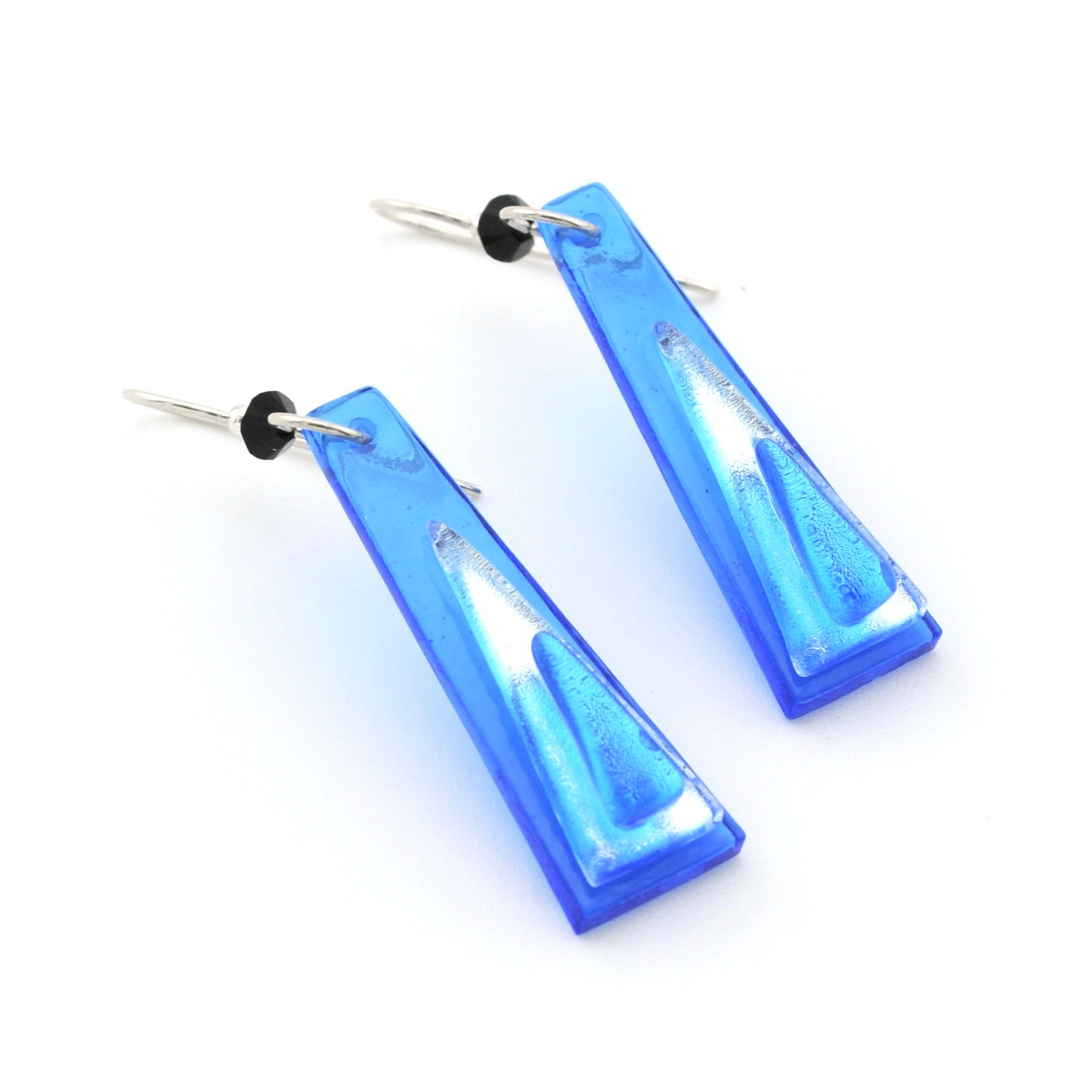 Blue glass dangle earrings on white background.