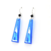 Blue glass earrings with black bead on white background.