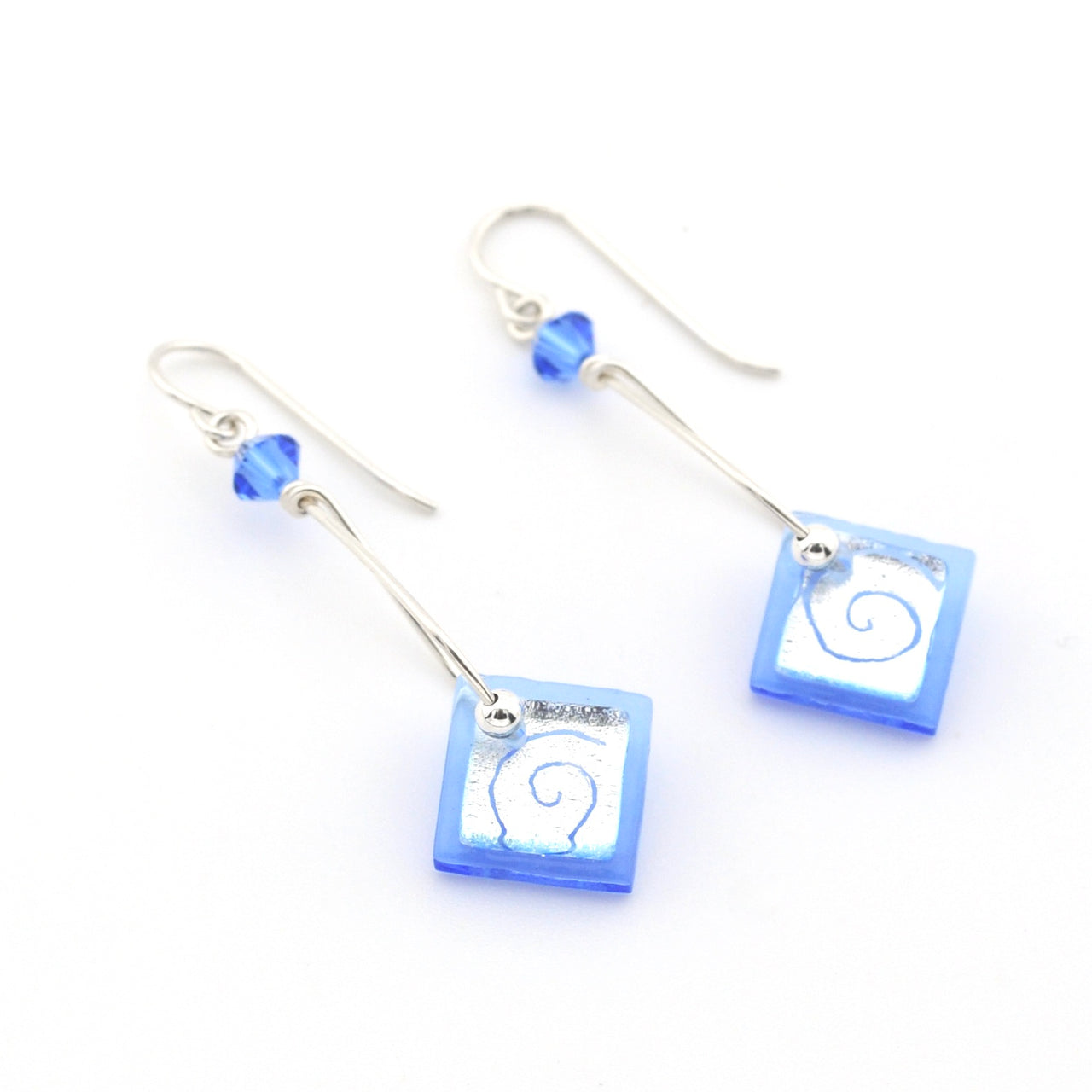 Blue glass dangle earrings on white background.