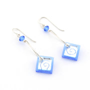 Blue glass dangle earrings on white background.