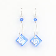 Pair of earrings with blue square beads and silver hooks on a white background