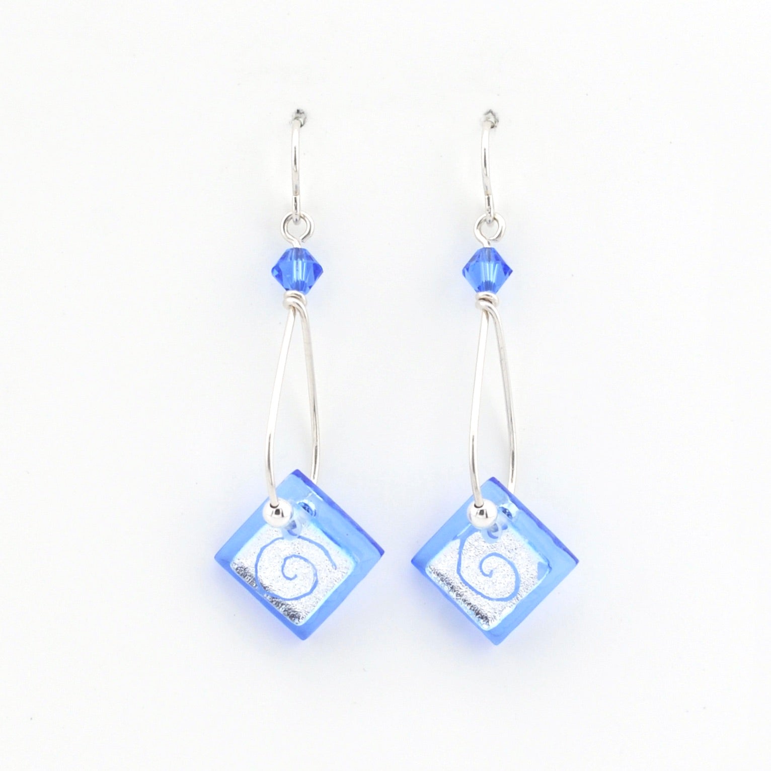 Pair of earrings with blue square beads and silver hooks on a white background