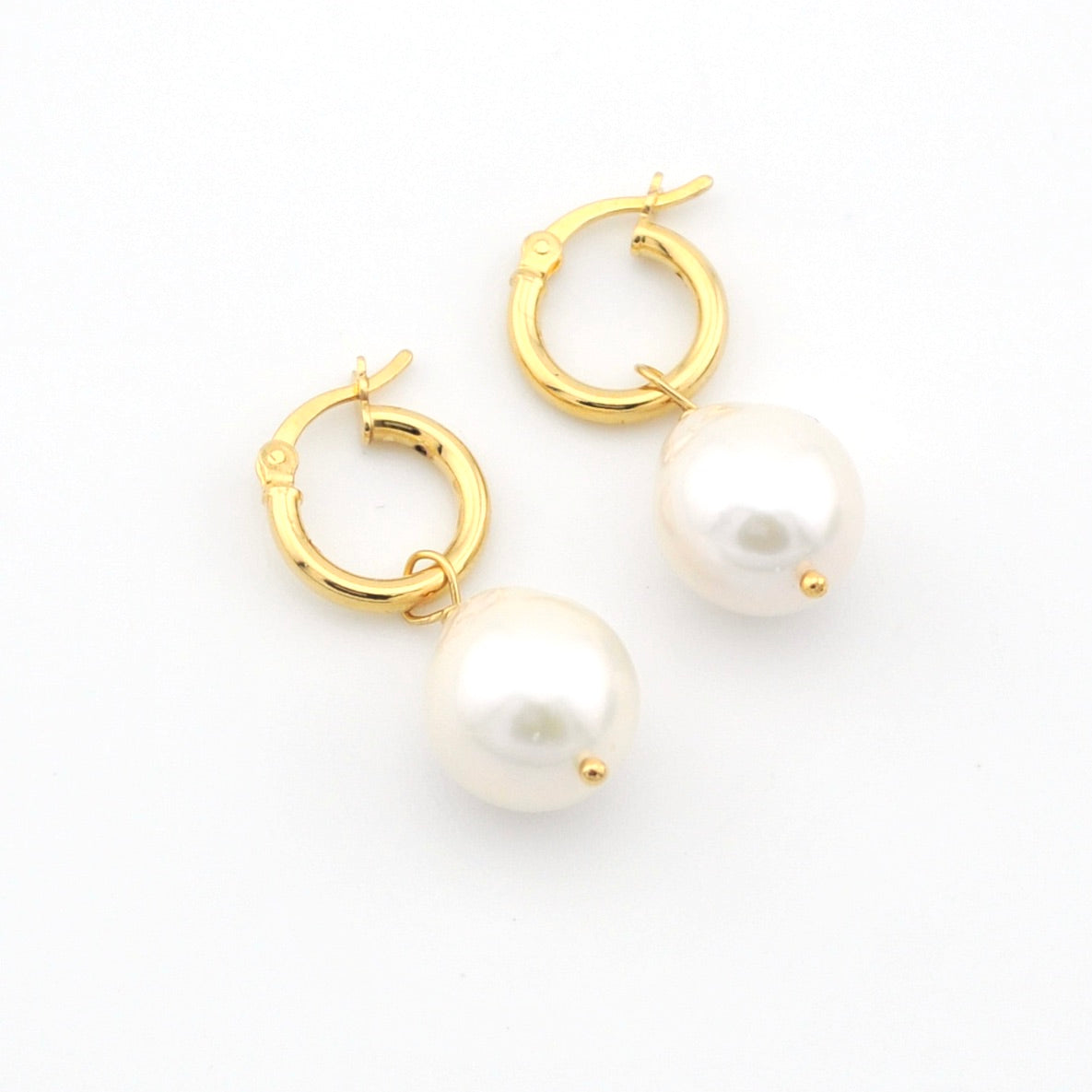 Gold hoop earrings with pearls on a white background