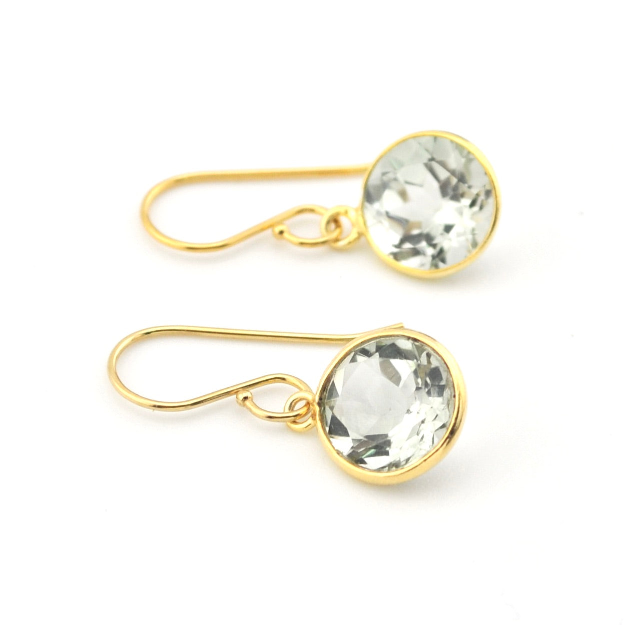 Gold earrings with clear gemstones on a white background