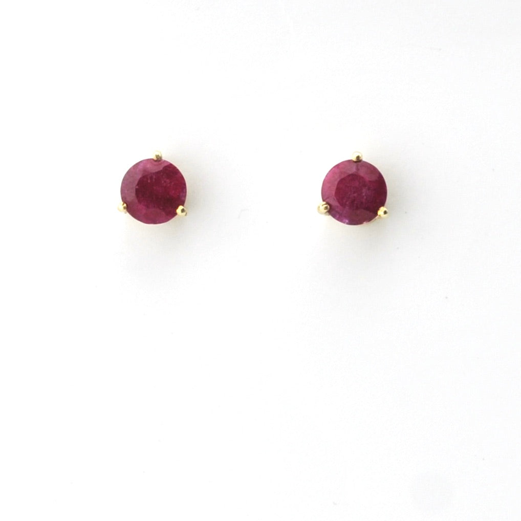 Pair of round ruby stud earrings on a white background