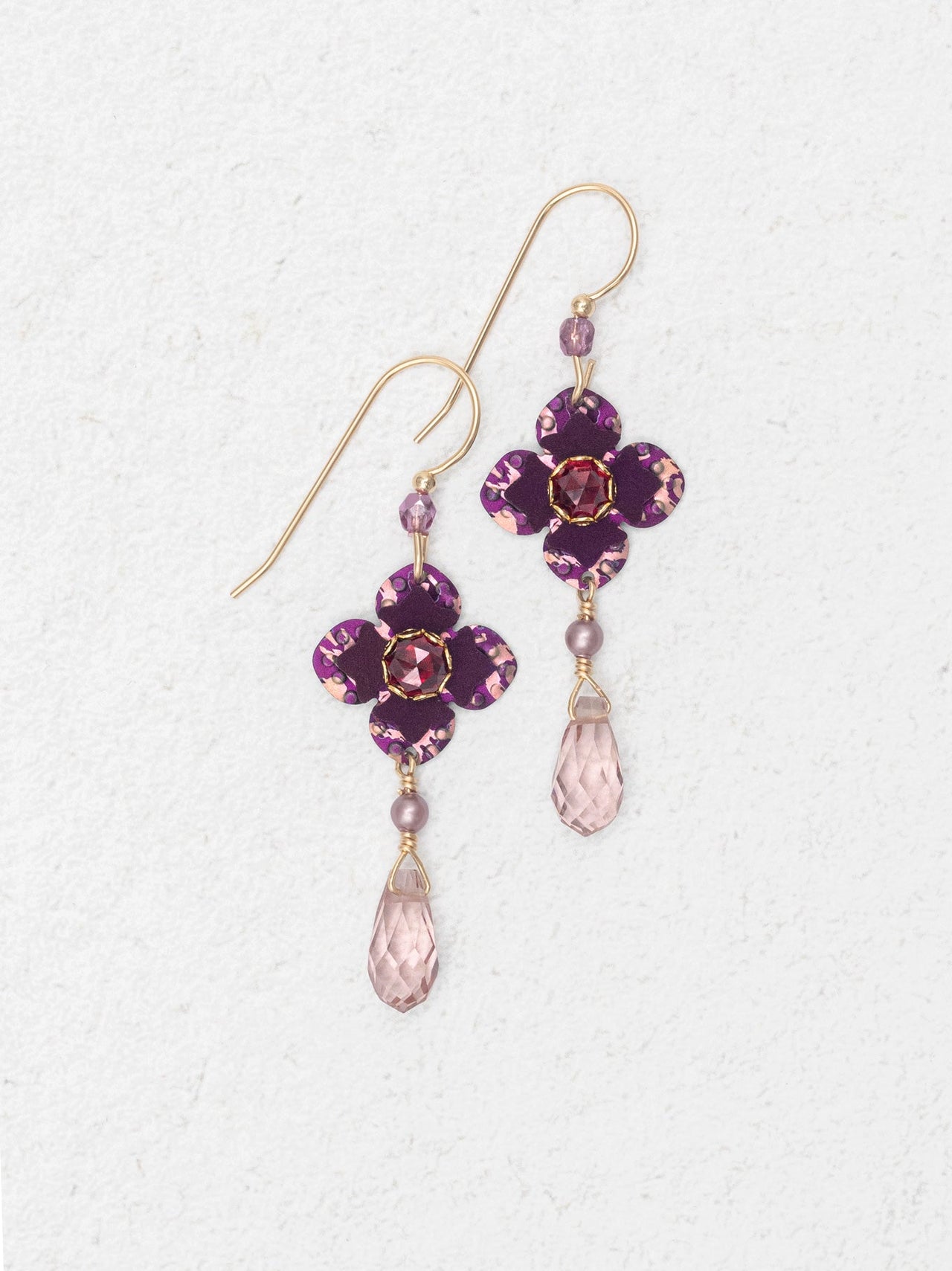 Purple flower-shaped earrings with pink teardrop beads on a white background