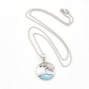 Silver necklace with a wave-shaped pendant featuring a blue stone on a white background