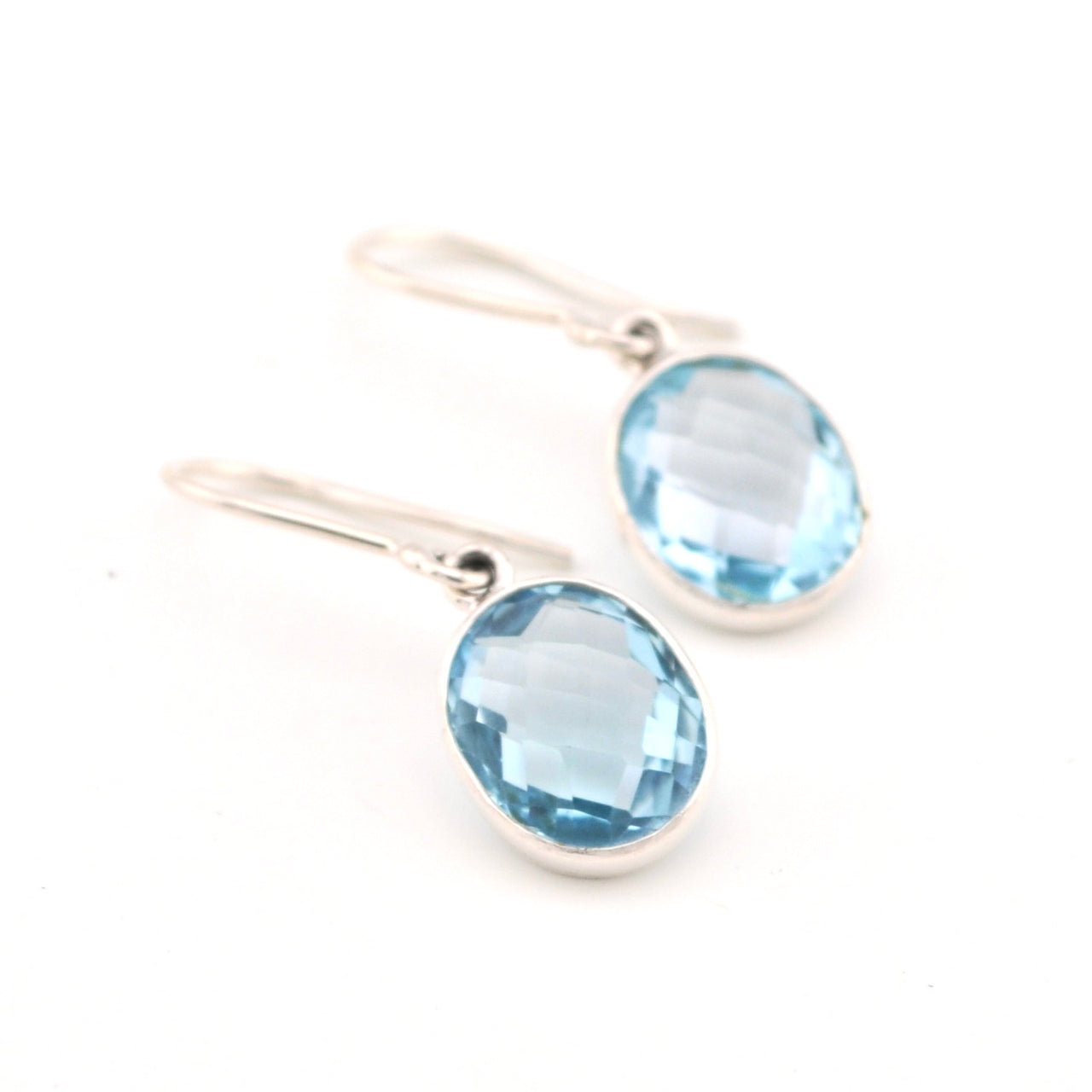 Silver earrings with blue gemstones on a white background