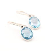 Silver earrings with blue gemstones on a white background
