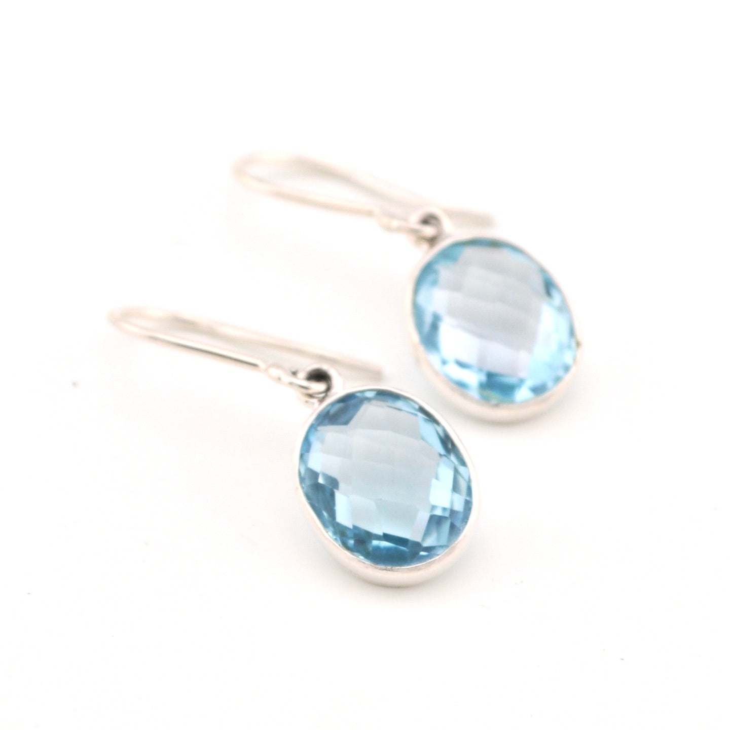 Silver earrings with blue gemstones on a white background