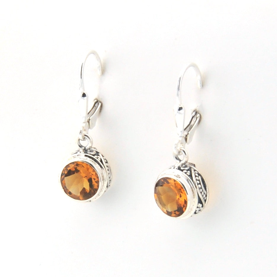 Pair of silver earrings with amber stones on a white background